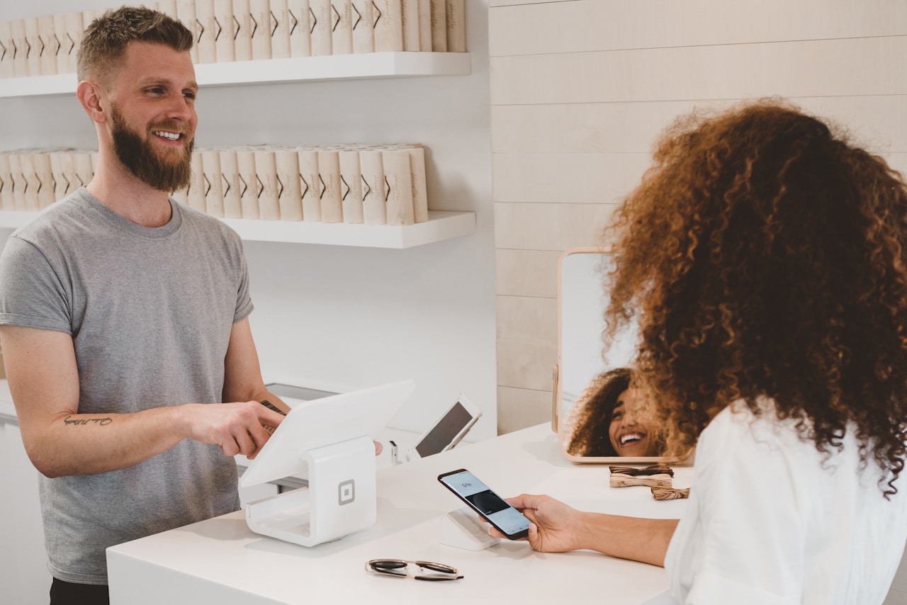 Business owner accepting a customer payment at a retail counter